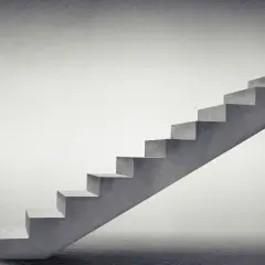 Minimalistyczne schody zabiegowe betonowe wiodą w górę, symbolizując postęp i rozwój.