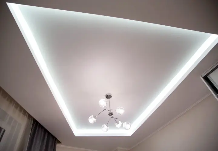Nowoczesny sufit napinany z podświetleniem LED tworzy niepowtarzalne inspiracje dla wnętrz. Stylowa lampa dodaje elegancji.