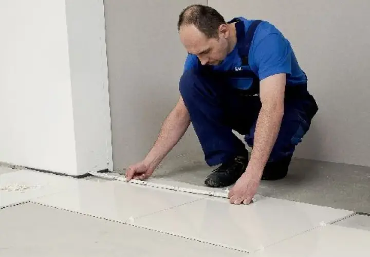 Fachowiec układa płytki 60x60, dbając o równe fugi. Wzory układania płytek są kluczowe dla estetyki.